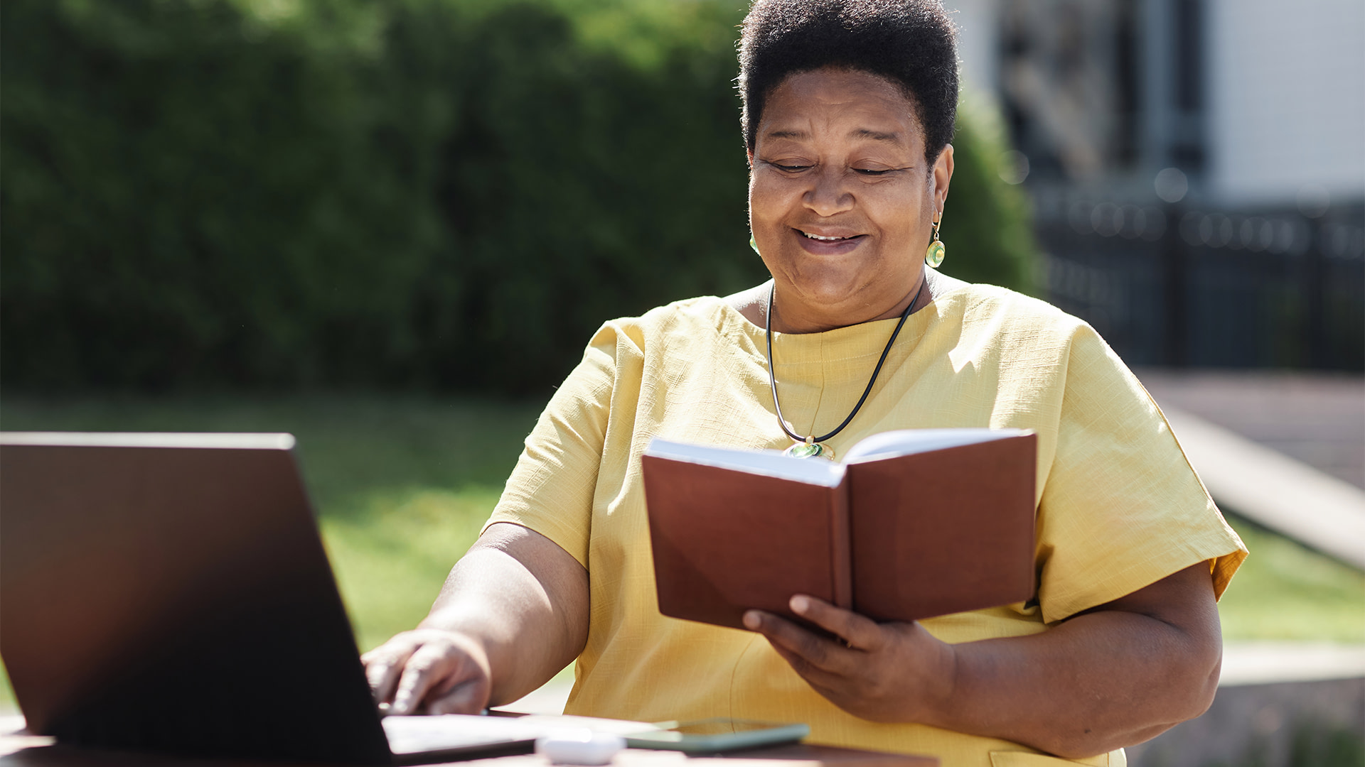 Woman reading while in front of her computer.