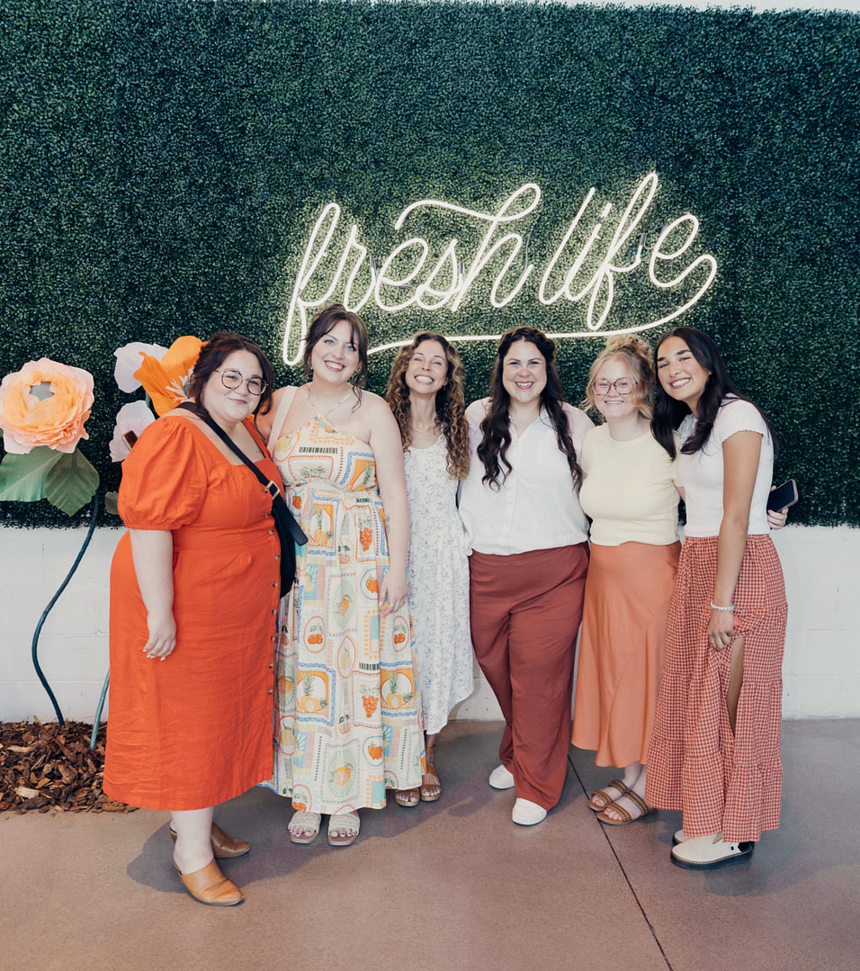 Ladies in front of a greenery wall