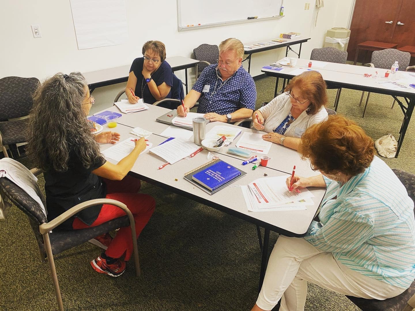 Group discussing and writing at conference table.