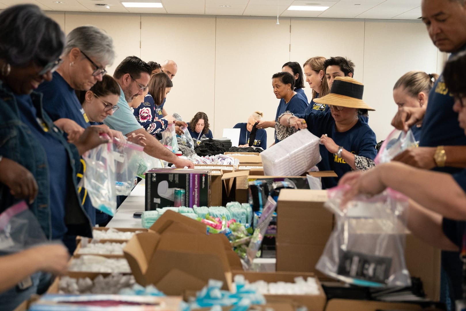 Volunteers assembling care packages on a table.