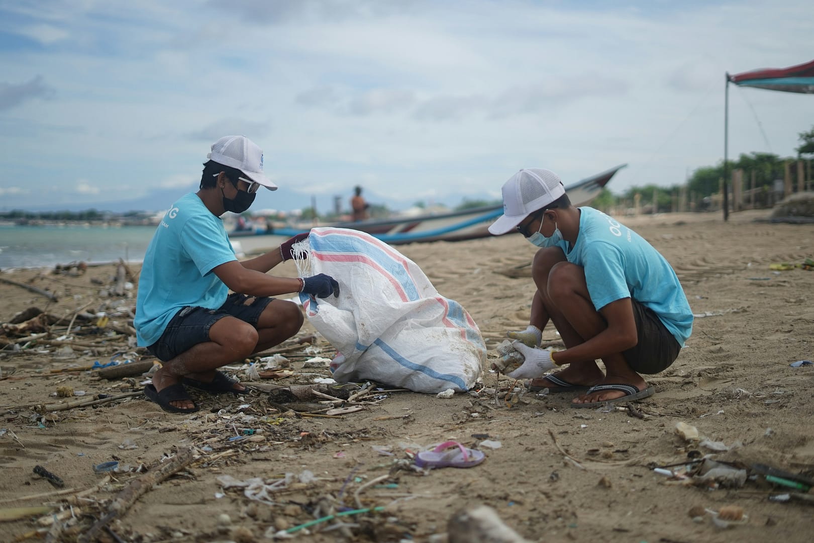 Volunteers collecting trash on a beach cleanup.