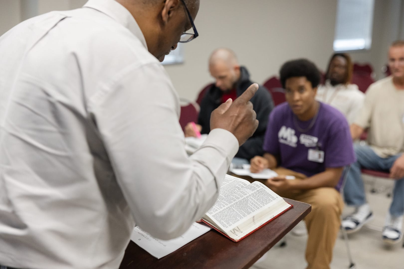 Person leading a classroom discussion with a book.