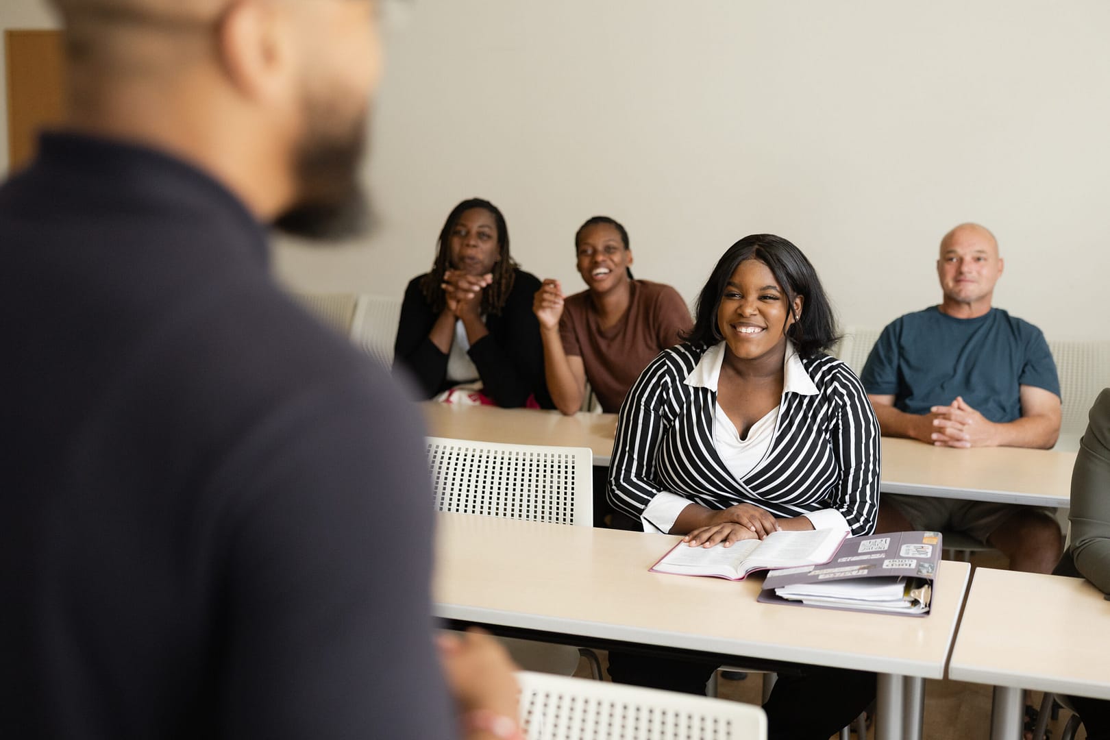 Teacher lecturing diverse students in classroom setting.