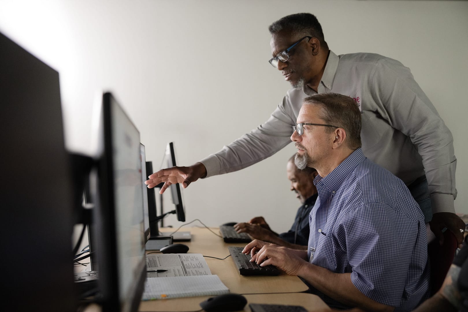 Instructor helps student in computer lab.