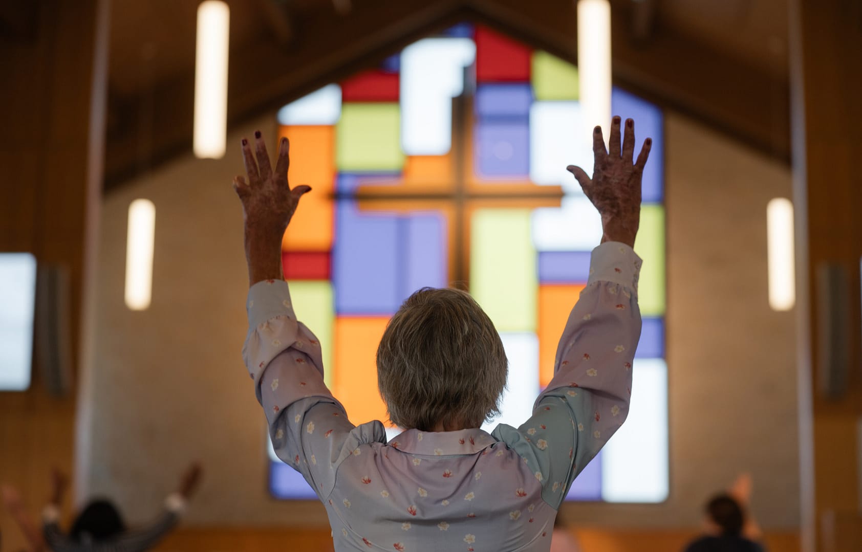 Person raising arms in a church.