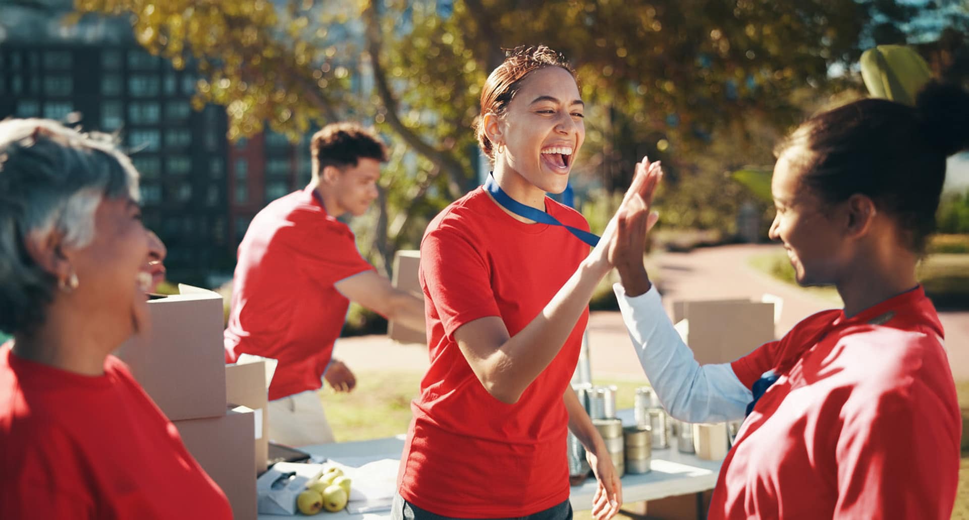 Volunteers high-five at outdoor event.