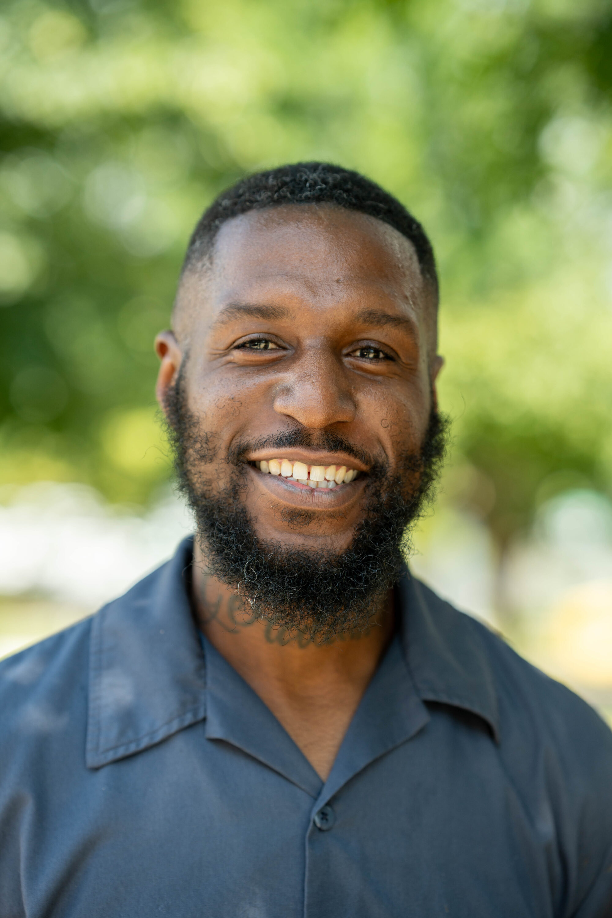 Smiling man outdoors with green background