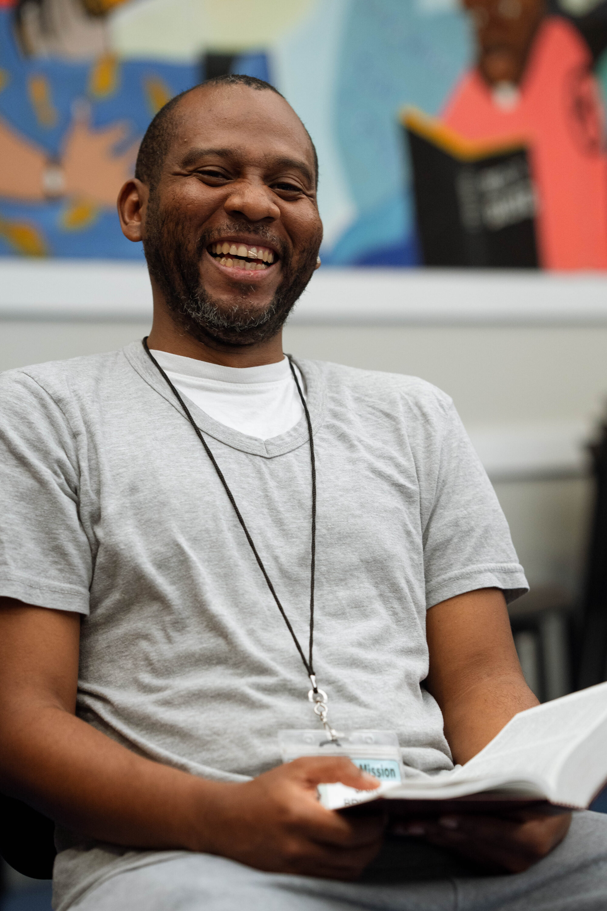 Smiling man reading a book indoors.