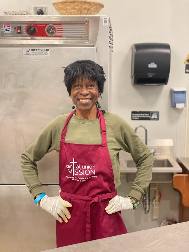 Smiling volunteer wearing Central Union Mission apron.