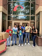 Volunteers at homeless recovery center with donated items.