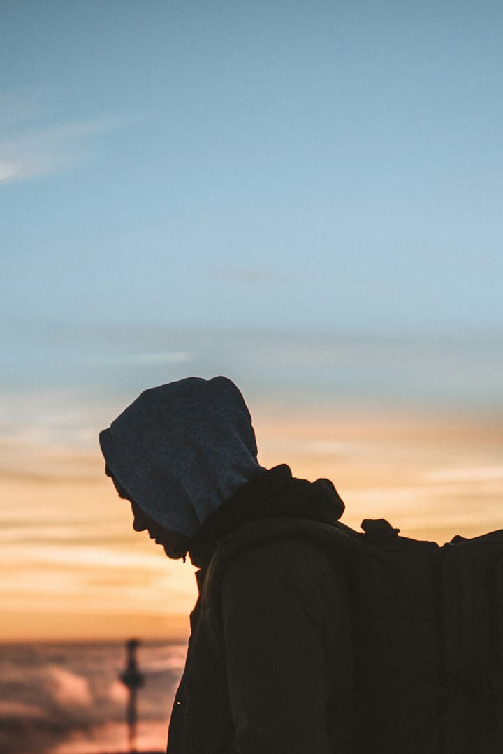 Silhouette of person with backpack at sunset