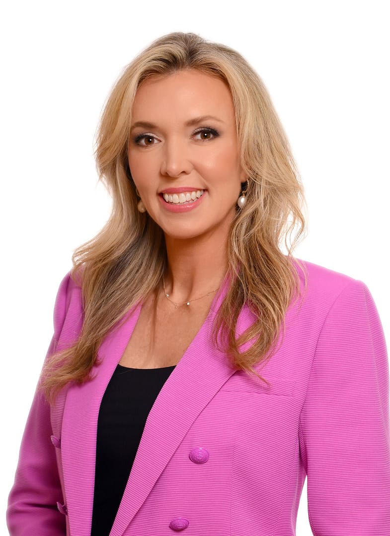 Smiling woman in pink blazer portrait.