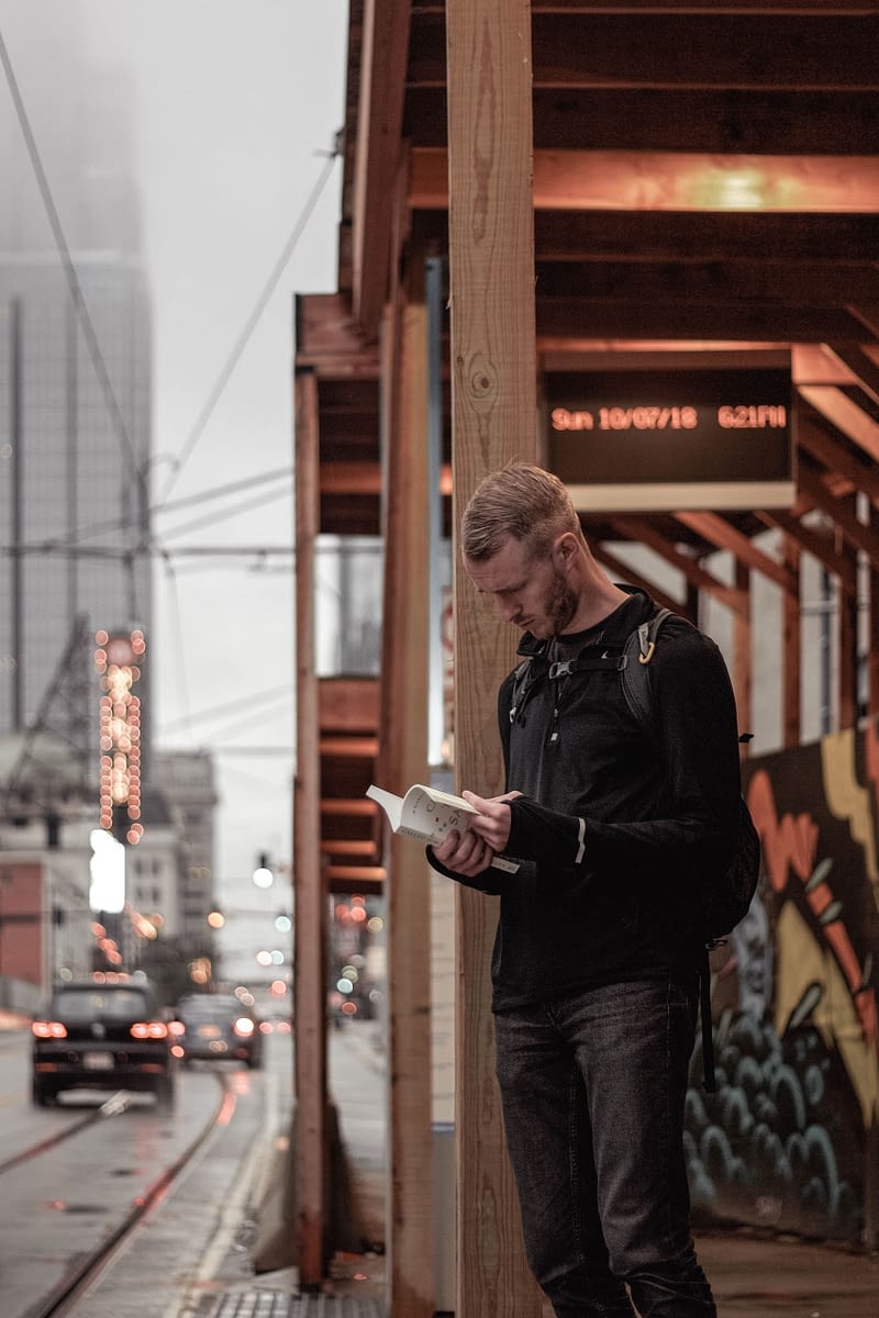 Man Reading Book at Train Station