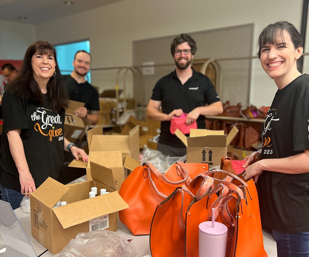 Volunteers packing donations in gift bags.